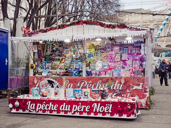 Un chalet commercial intitulé "La pêche du père Noël" avec plein de petites cartes colorées et un bac rouge ou se trouvent des boules de noël flottantes.
