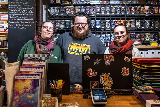 Trois personnes souriantes entourées de jeux de société