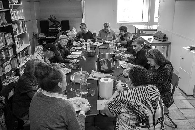 Une dizaine de personnes partageant un repas autour d'une grande table.