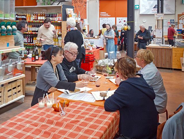 Convives à une table tandis que d'autres personnes en arrière plan.